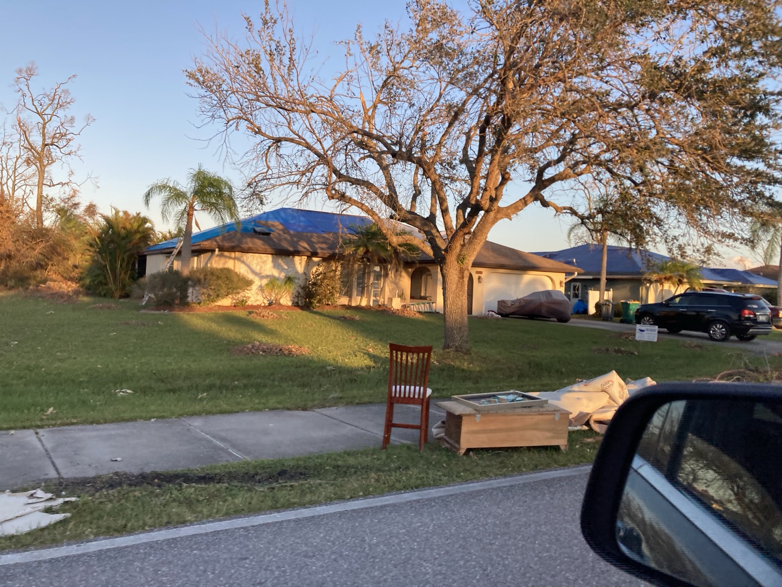 Roof with missing shingles and storm damage awaiting emergency tarping